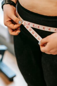 Woman measuring her waist